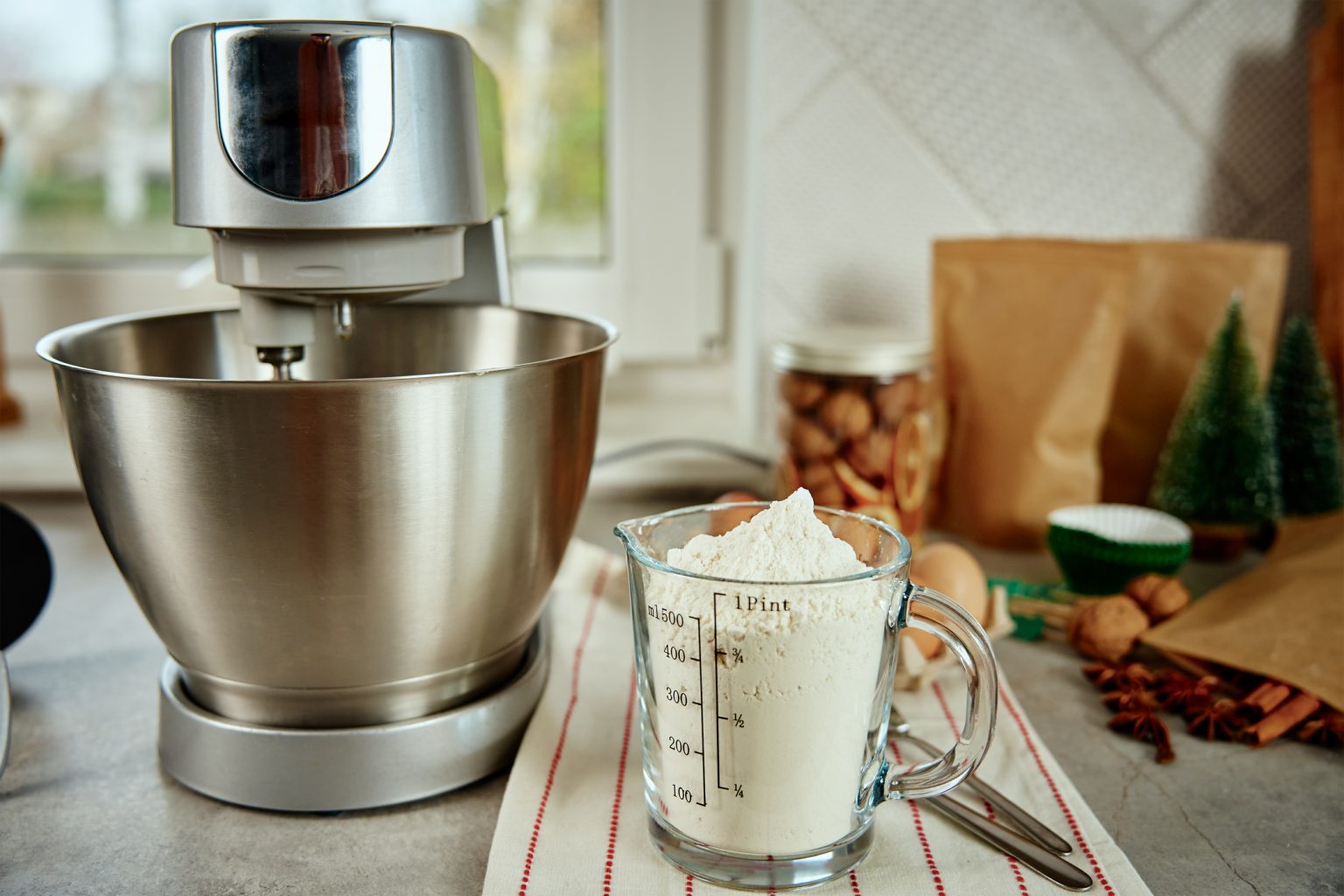 Preparation of dough in an electric mixer at home. Professional mixer for kneading dough and food ingredients in kitchen interior. Modern appliances in the kitchen